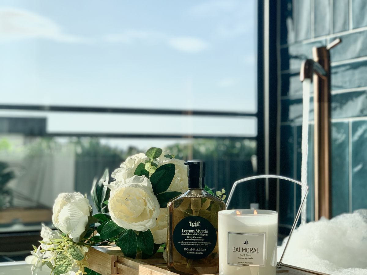 Baignoire avec plateau, bougie et fleurs